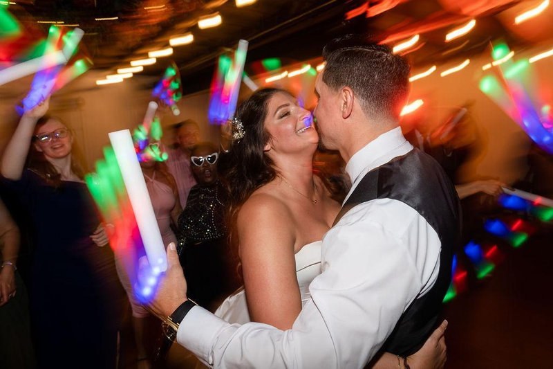 Newlyweds celebrating with colorful glow sticks