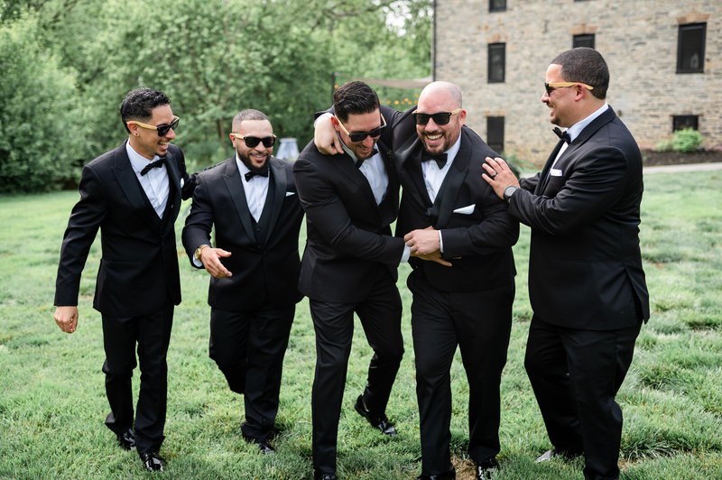Groom and groomsmen laughing together