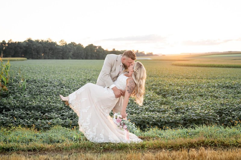 Newlyweds in a field at sunset