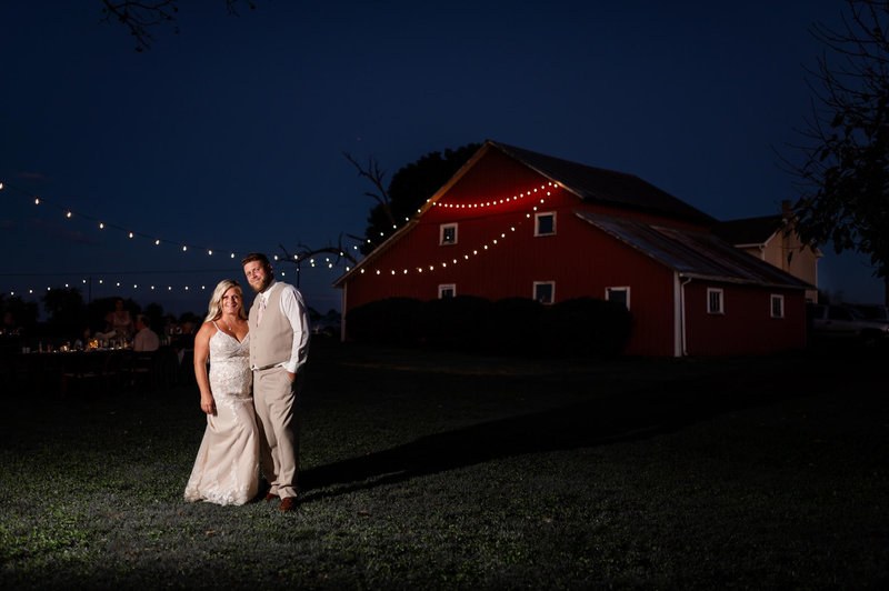 Evening wedding portrait with a red barn