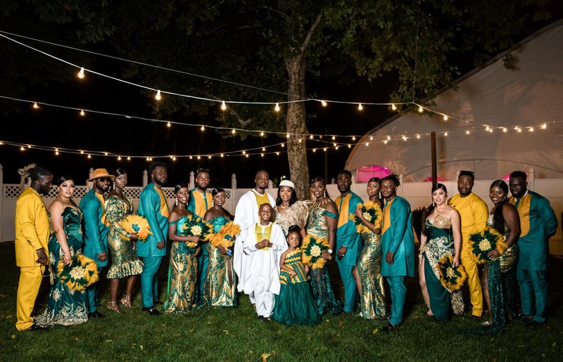 Wedding group in colorful attire under string lights