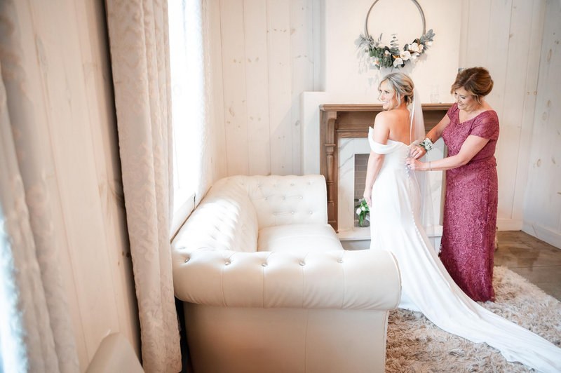 Helping the bride into her wedding dress