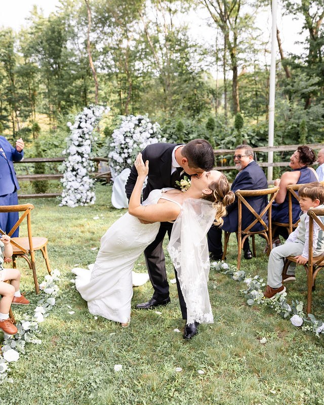 Newlyweds sharing a kiss at their outdoor ceremony