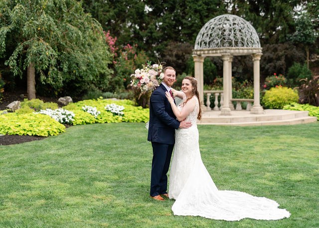 Newlyweds smiling together in a formal garden