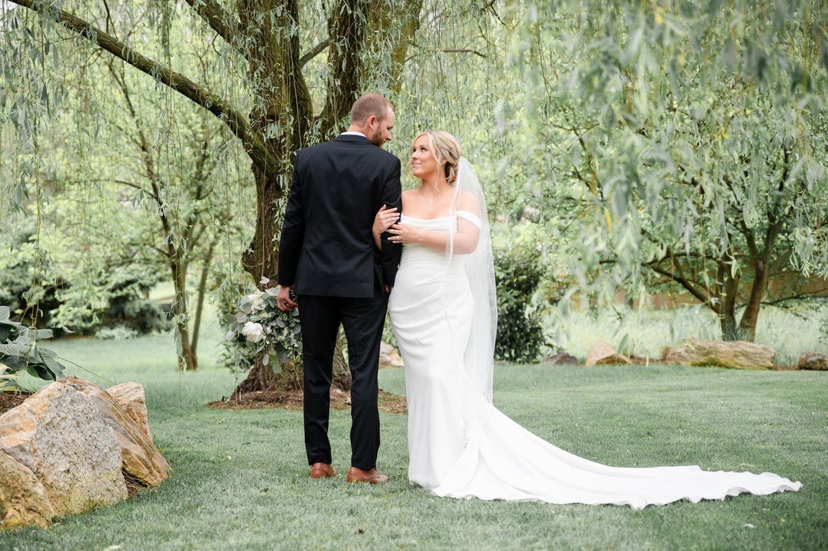 Newlyweds together under a willow tree