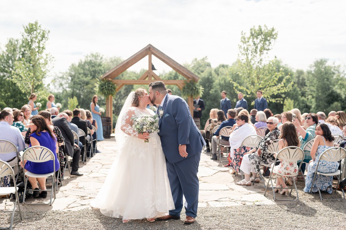 Newlyweds walking down the outdoor ceremony aisle