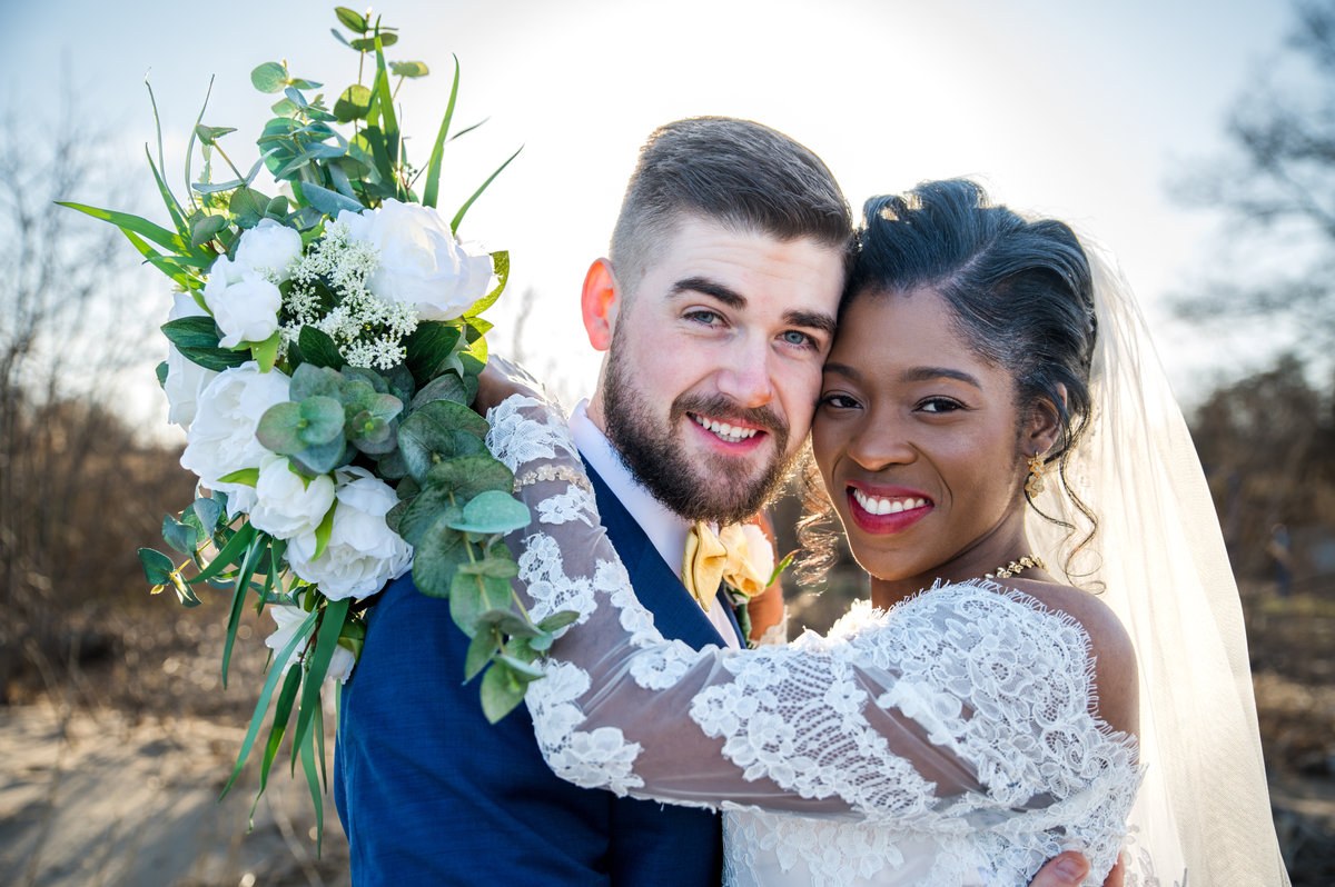 Newlyweds smiling together with their wedding flowers