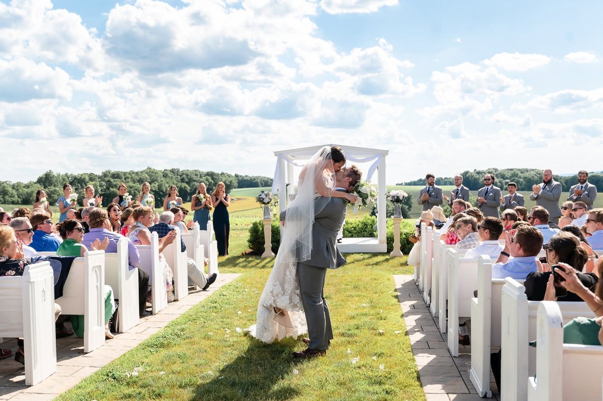 Couple kissing as their ceremony guests watch