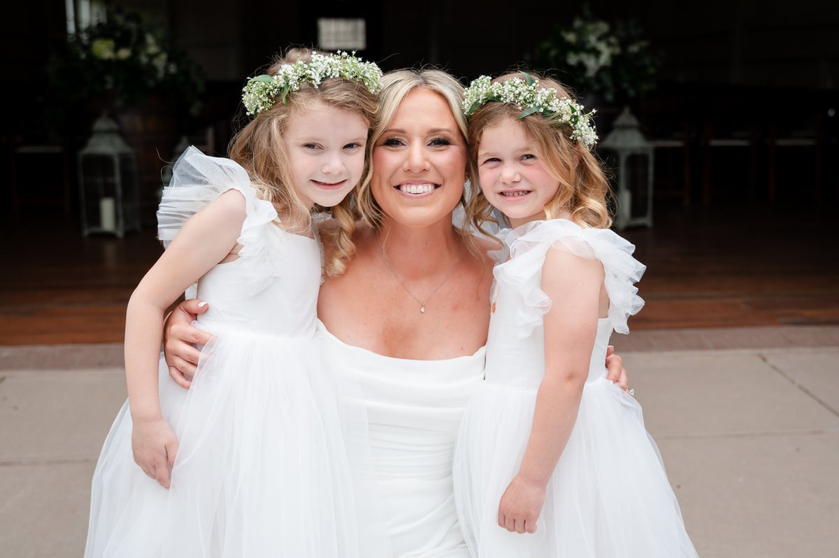 Bride smiling with two young wedding attendants
