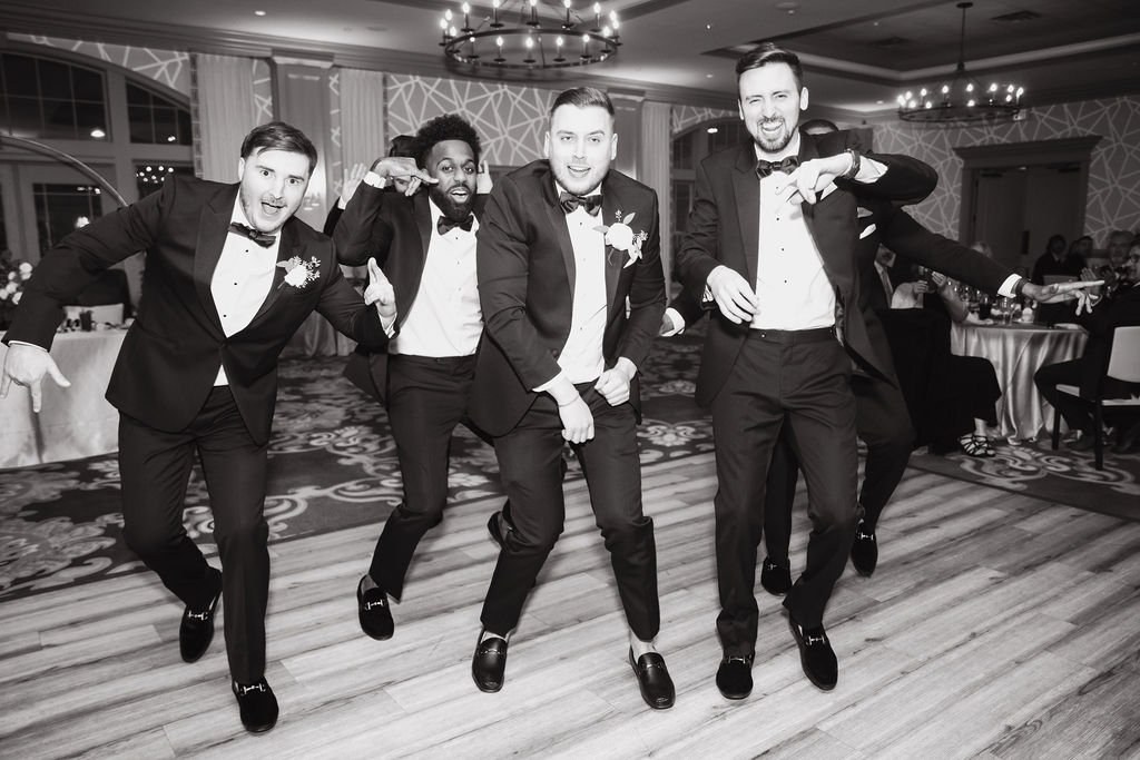 Groomsmen walking together in black and white